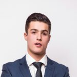portrait of happy smiling young businessman in blue suit isolated on white background. business success concept.